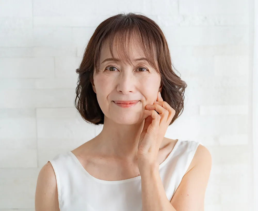 顔を触る中年女性